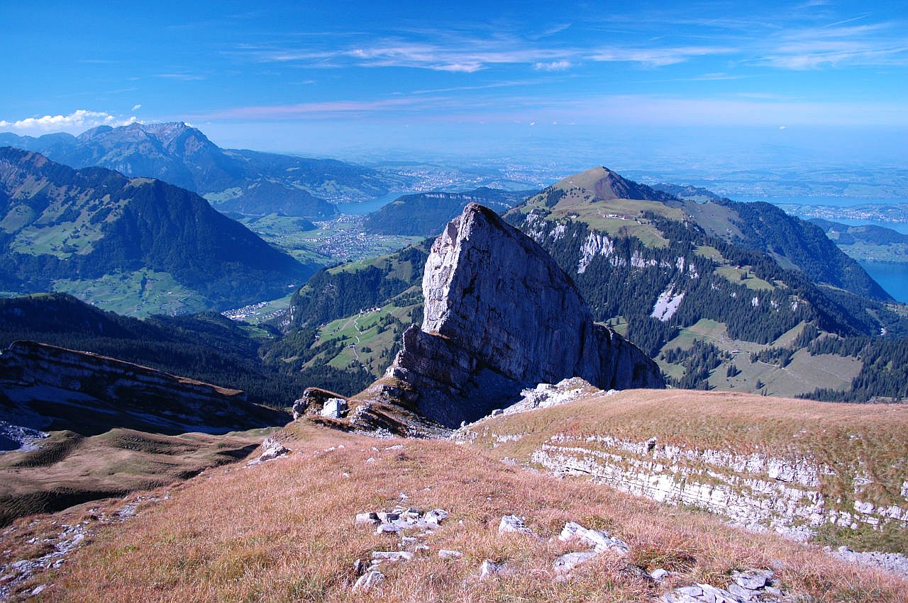 Auf dem Bild sieht man von Steinalper Jochli nach Norden. In der Bildmitte dominiert der Zwelfer, ein Felsklotz aus Kalk. Rechts dahinter erhebt sich die grasige Pyramide des Buochserhorns. Hinter den Gipfeln erkennt man Luzern und sein Vororte, einen Teil des Vierwaldstättersees und davor den Kantonshauptort von Nidwalden, Stans. Im Vordergrund hat es Alpweiden, die im Herbst schon braun sind. Sie sind mit einigen Kalksteinen durchsetzt. Auch in der rechten Bildhälfte ist der Vierwaldstättersees in Ausschnitten zu erkennen. Links überragt das Pilatus-Massiv alle anderen Gipfel. Der Himmel ist blau und wird von wenigen Schleierwolken verziert. Nur über dem Pilatus-Massiv hat es einige Quellwolken. Der Blick geht an diesem klaren Tag sehr weit ins Schweizer Mittelland hinaus.